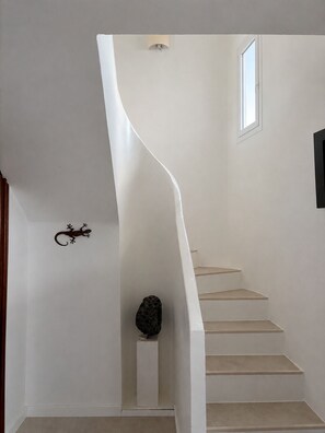 A white staircase with a unique curved design leading to a landing. - Villa Lava - 3-Bedroom Villa in Downtown Puerto del Carmen (Tías)