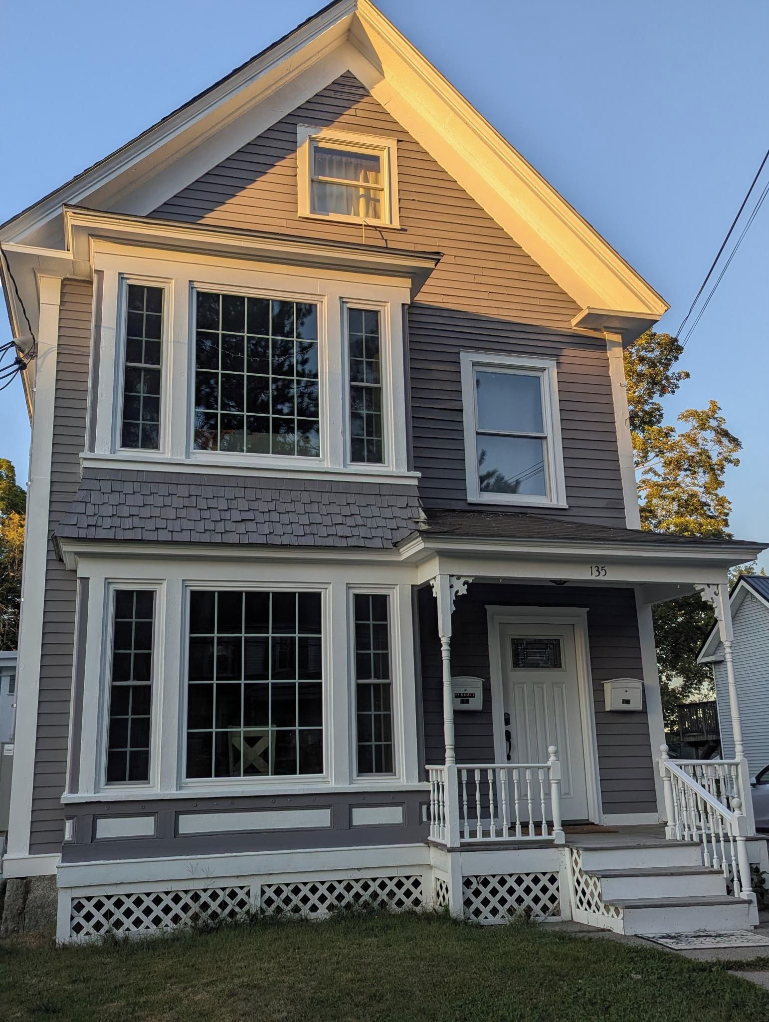 A two-story house with a front porch, a garage, and a small attached garage.