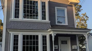 A two-story house with a front porch, a garage, and a small attached garage.