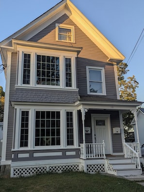 A two-story house with a front porch, a garage, and a small attached garage.