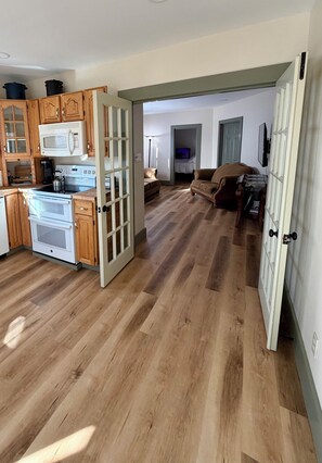 A spacious kitchen with wooden cabinets, a microwave, and a stove.