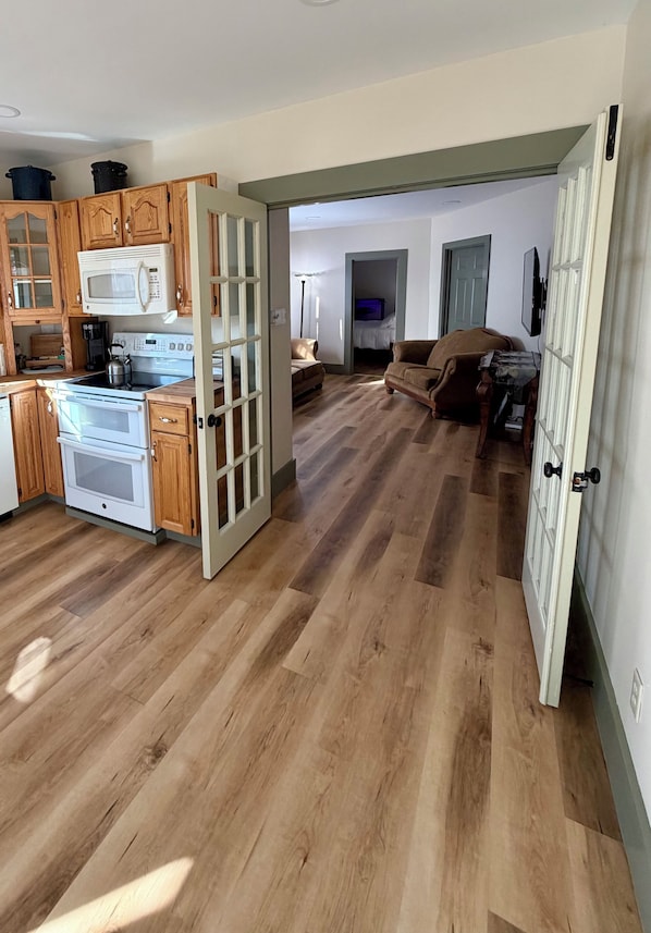 Una cocina amplia con armarios de madera, microondas y estufa.