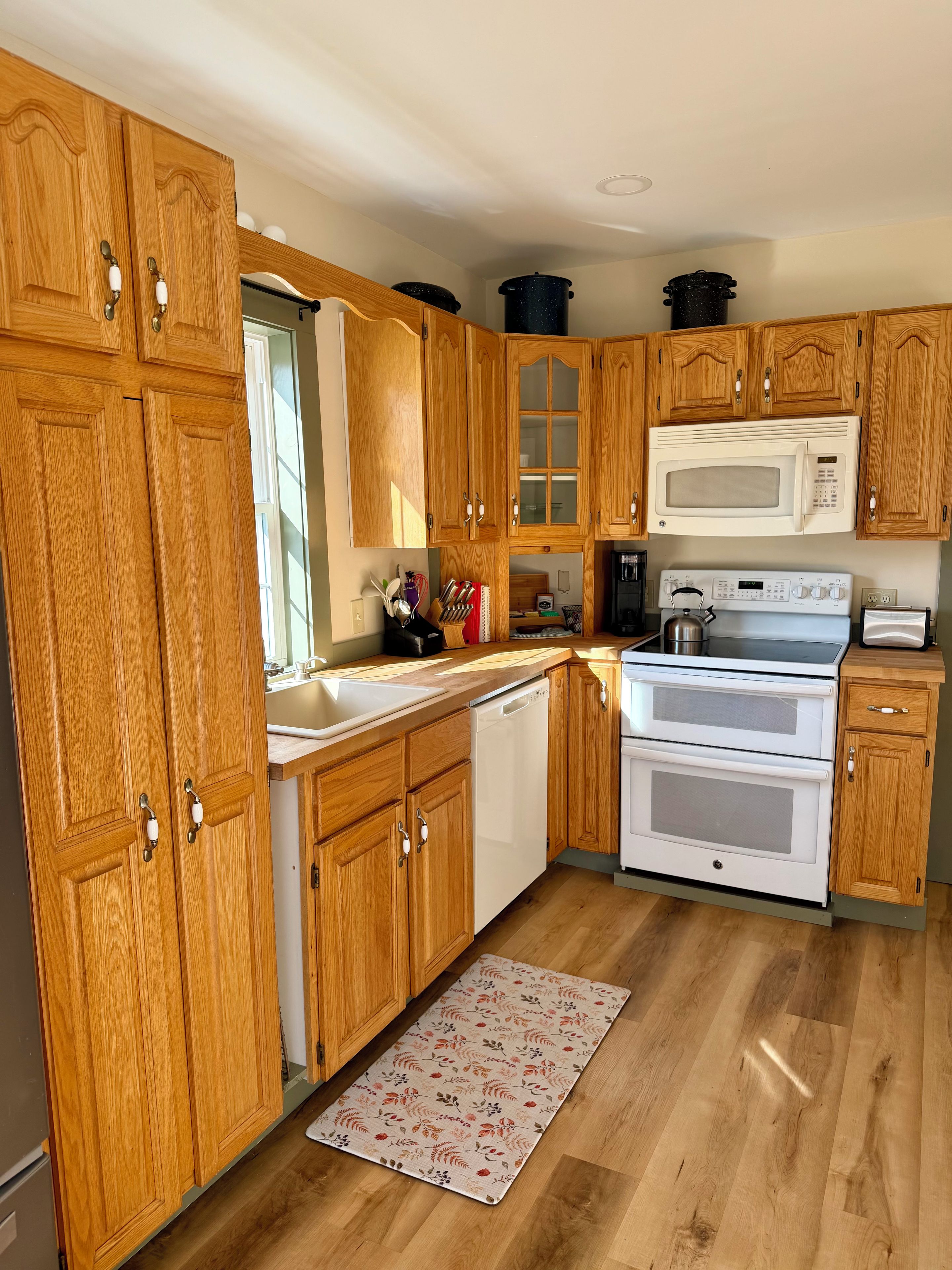 A kitchen with wooden cabinets, a microwave, an oven, and a dishwasher.