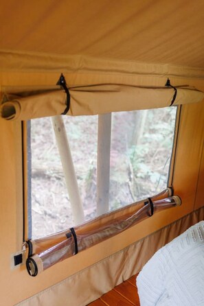 Una tenda amb finestra, zona de dormir i vista a l'exterior.