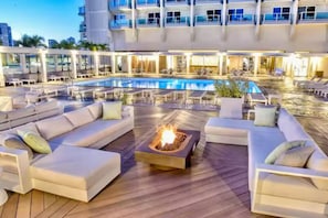 A rooftop pool area with lounge seating and a fire feature. - 11F-Upscale King Suite-Corner Unit-Ala Moana Hotel (Honolulu)