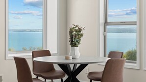 A dining area with a round table, six chairs, and a potted plant. - Perched Above Cayuga ·  Sauna · Winery On-Site (Romulus)