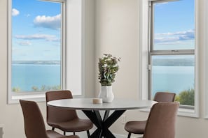 A dining area with a round table, six chairs, and a potted plant. - Perched Above Cayuga ·  Sauna · Winery On-Site (Romulus)