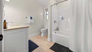 A modern bathroom with a bathtub, toilet, and sink. - Perched Above Cayuga ·  Sauna · Winery On-Site (Romulus)