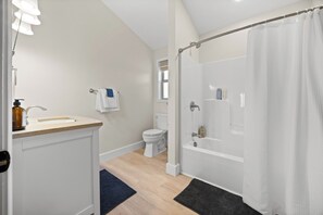 A modern bathroom with a bathtub, toilet, and sink. - Perched Above Cayuga ·  Sauna · Winery On-Site (Romulus)