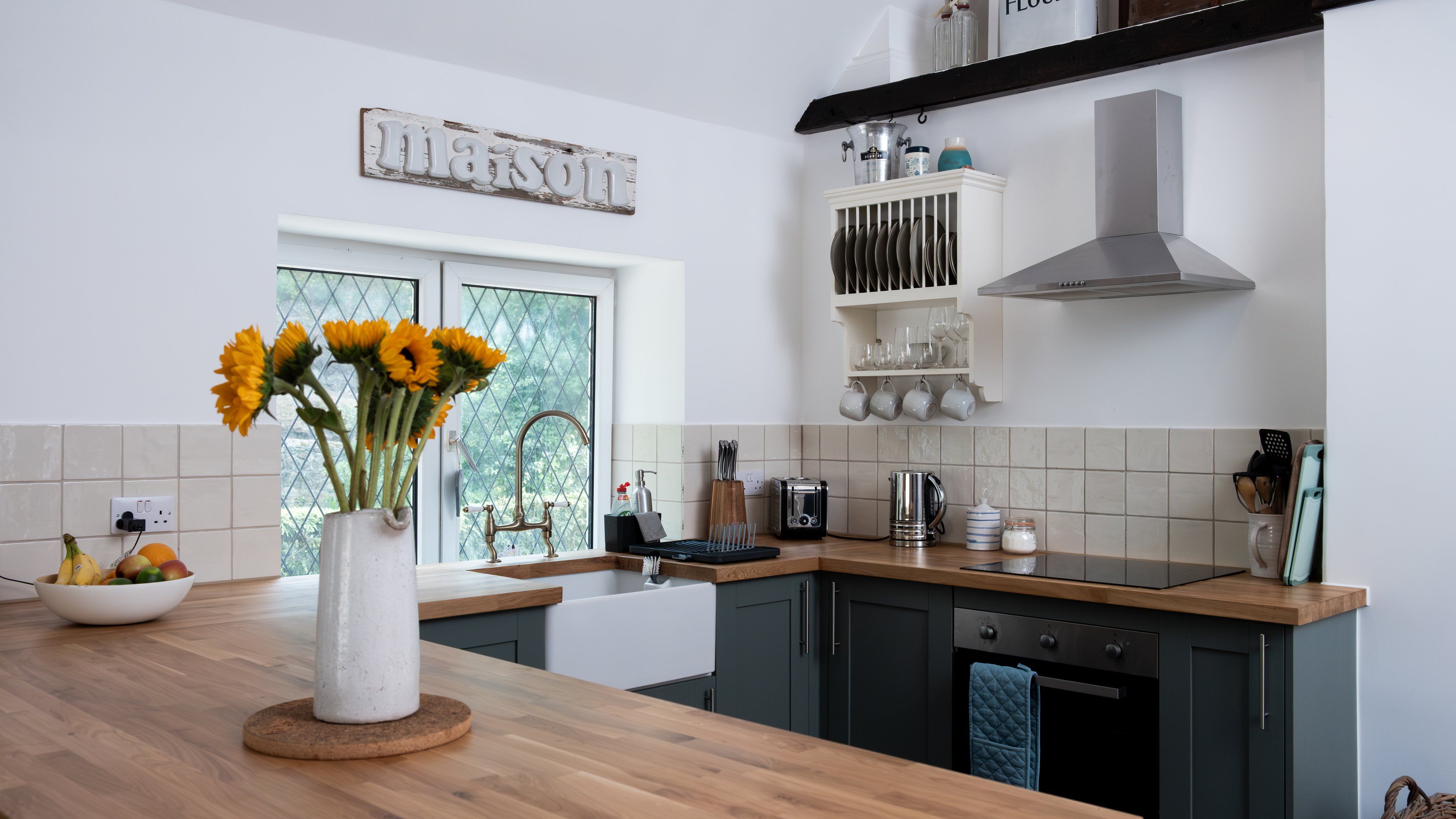 A modern kitchen with a wooden countertop, a sink, and a window with a view.