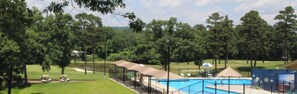Un campo de golf con piscina, zonas de estar cubiertas y un pabellón.