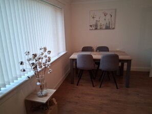 A dining area with a table and four chairs, a window with blinds, and a painting on the wall. - Cosy and bright spacious 3 bedroom house in a quiet cul de sac area in Culloden (Culloden)