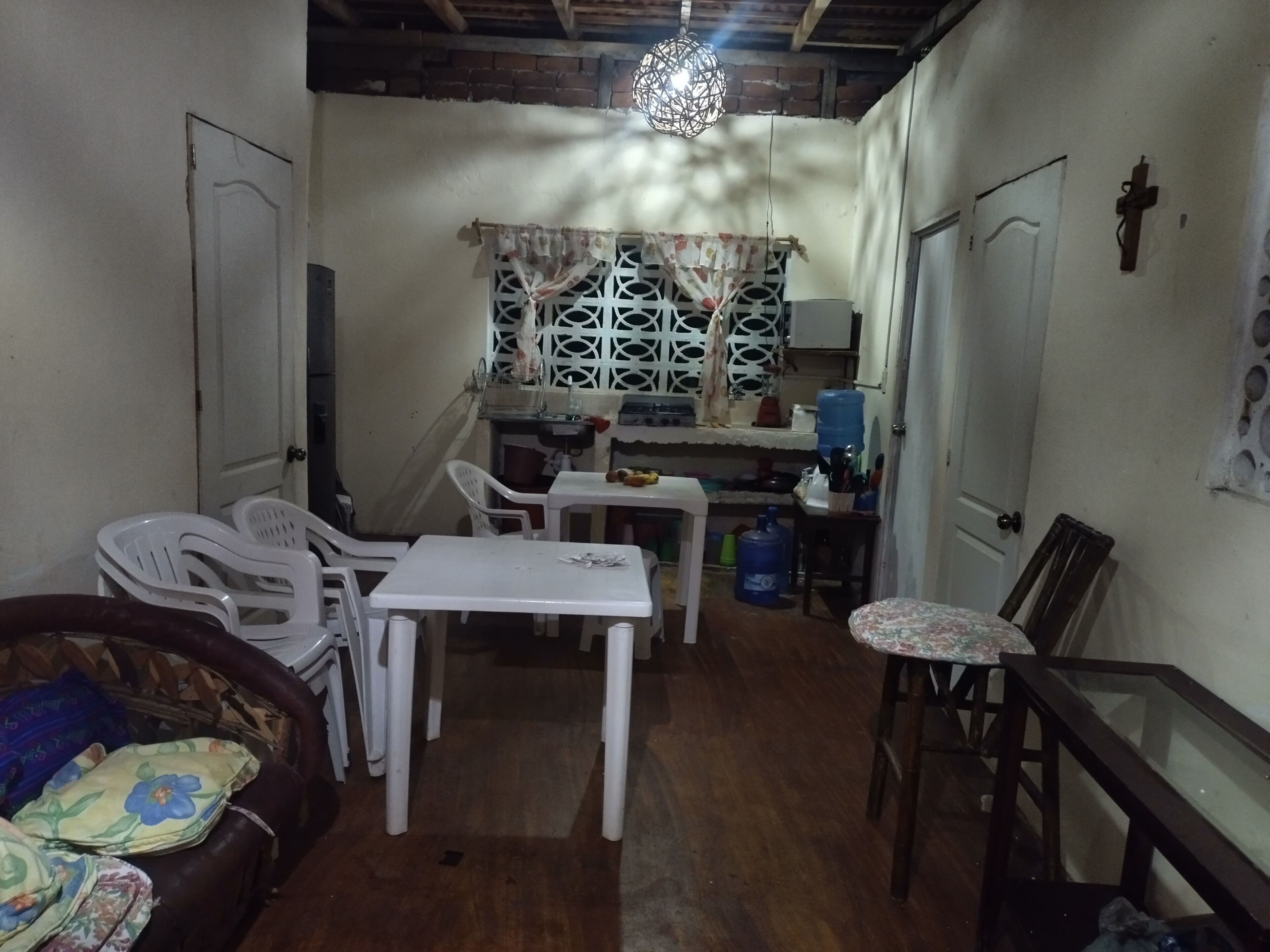 A compact living space with a dining area, a small kitchen, and a seating area with a sofa and chairs.