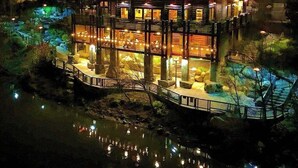 A multi-story building with a balcony and a dock extending over a body of water. - Cozy Queen Suite 104 –Stroll Historic Downtown, Great Restaurants & Unique Shops (Grants Pass)