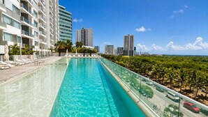 Ein Pool mit Liegestühlen und Blick auf hohe Gebäude.