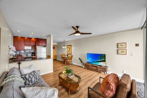 A modern living room with a sofa, a coffee table, and a television.