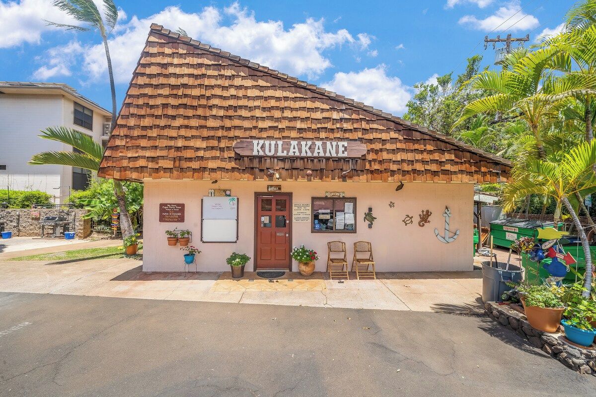 A building named 'KULAKANE' with a tiled roof, a wooden door, and a signboard.