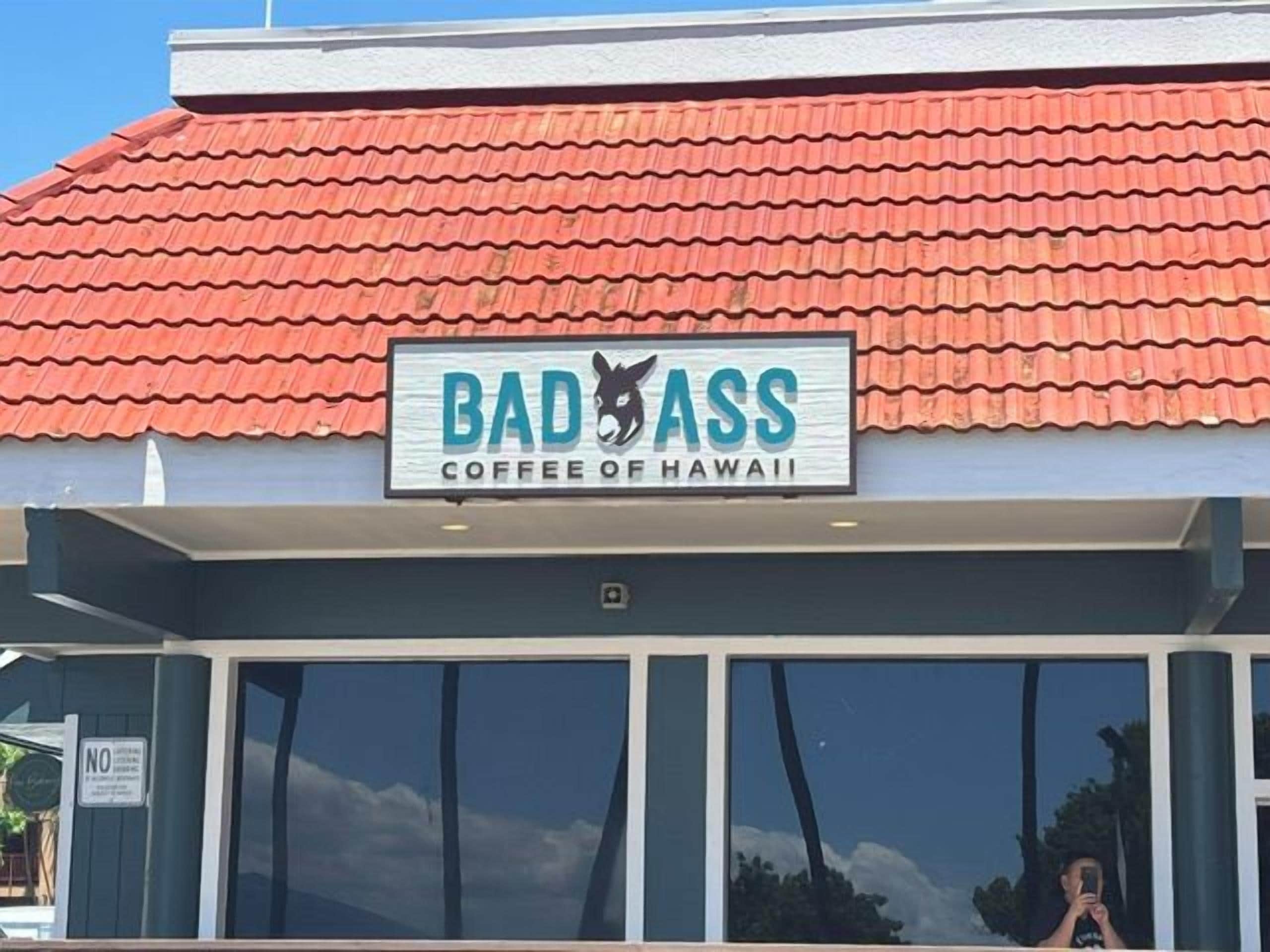 A storefront with a sign that reads 'BAD ASS COFFEE OF HAWAII.'