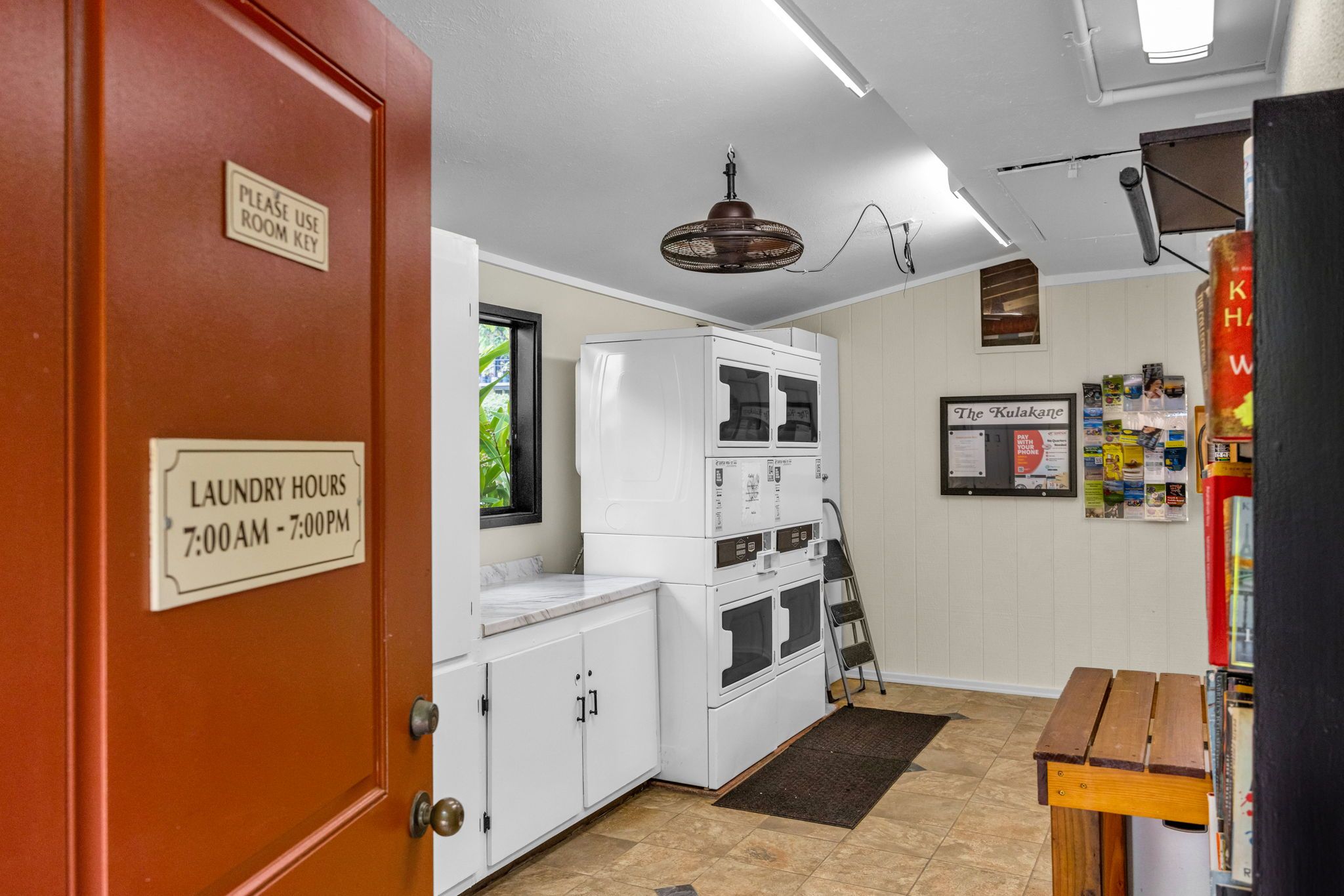 A laundry room with a sign indicating laundry hours from 7:00 AM to 7:00 PM.