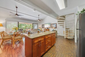 A spacious kitchen with a large island, wooden cabinets, and a spiral staircase. - Remodeled 3BD w AC Pool Near Sandy Beach - Koa Resort 3J (Kihei)