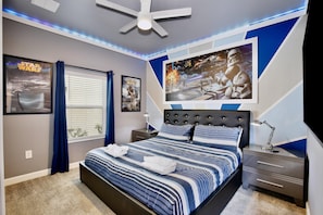 A bedroom with a bed, nightstands, a ceiling fan, Star Wars posters, and a window with curtains. - 4323 Scene | 5BR Waterview Townhome (Kissimmee)