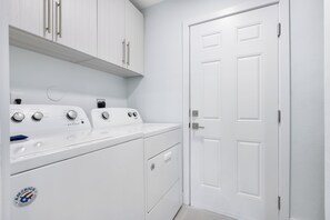 A laundry room with a white washing machine, dryer, and cabinets. - Serene Waterfront Bliss – Private Pool Home Near Beach Access, Sleeps 8 (Marco Island)