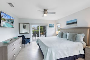 A bedroom with a large bed, a ceiling fan, a TV, and a view of the outside. - Serene Waterfront Bliss – Private Pool Home Near Beach Access, Sleeps 8 (Marco Island)
