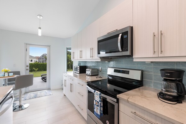 A modern kitchen with a built-in microwave, toaster, and coffee maker.
