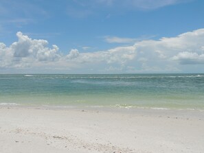 A beach with a clear sky and calm sea.