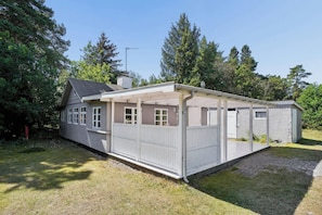 A single-story house with a covered porch, a chimney, and a satellite dish.