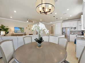 A modern kitchen with white cabinetry, a central island, and a chandelier. - Resort-Style Naples Living in Winding Cypress- Private Pool, Spa & Waterfront (Naples)