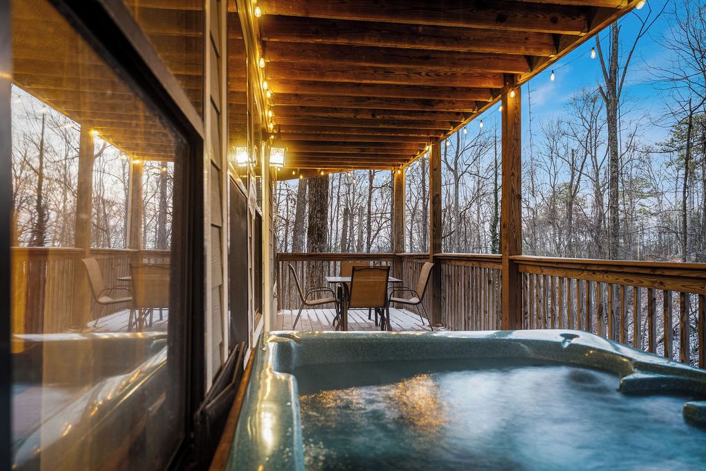 A hot tub on a wooden deck with a view of trees.