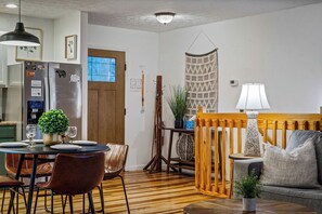 A dining area with a wooden table, chairs, and a potted plant. - Locklyn's Loft Views, Hot Tub, Game Room & MORE! (Gatlinburg)