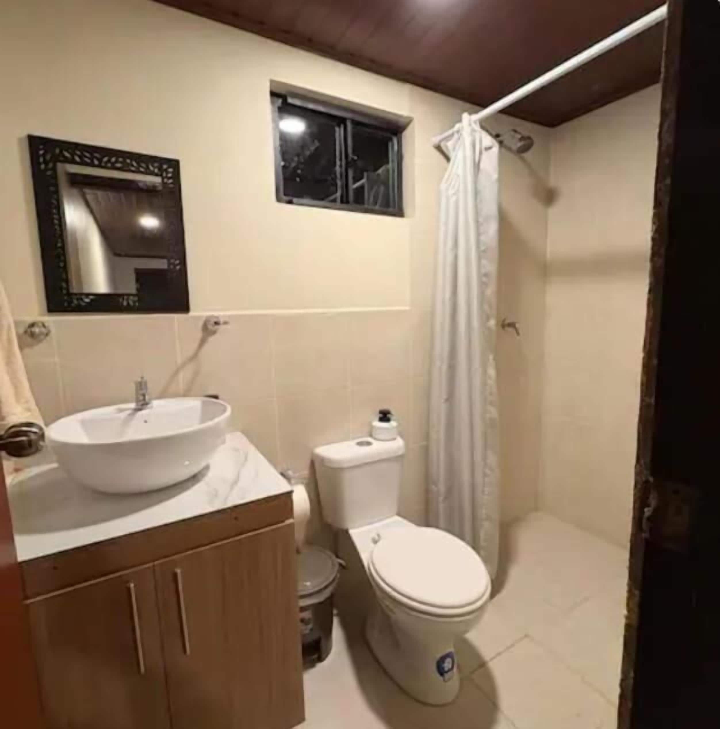 Uma casa de banho com lavatório, sanita e cortina de chuveiro.