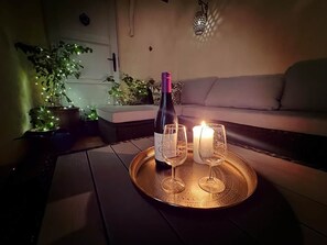 A table with a bottle of wine, two glasses, and a candle, set on a tray. - Charming Historic Townhouse with Private Terrace in Old Agde (Agde)