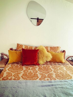 A bed with patterned bedding, a mirror above it, and two nightstands with lamps. - Charming Historic Townhouse with Private Terrace in Old Agde (Agde)