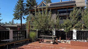 Un edificio dal design moderno, con una terrazza in legno e un tavolo da picnic.