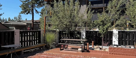 A building with a modern design, featuring a wooden deck and a picnic table.