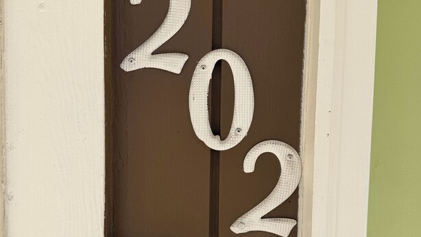 Una porta con i numeri '202' e un campanello con l'etichetta 'Master Lock'.