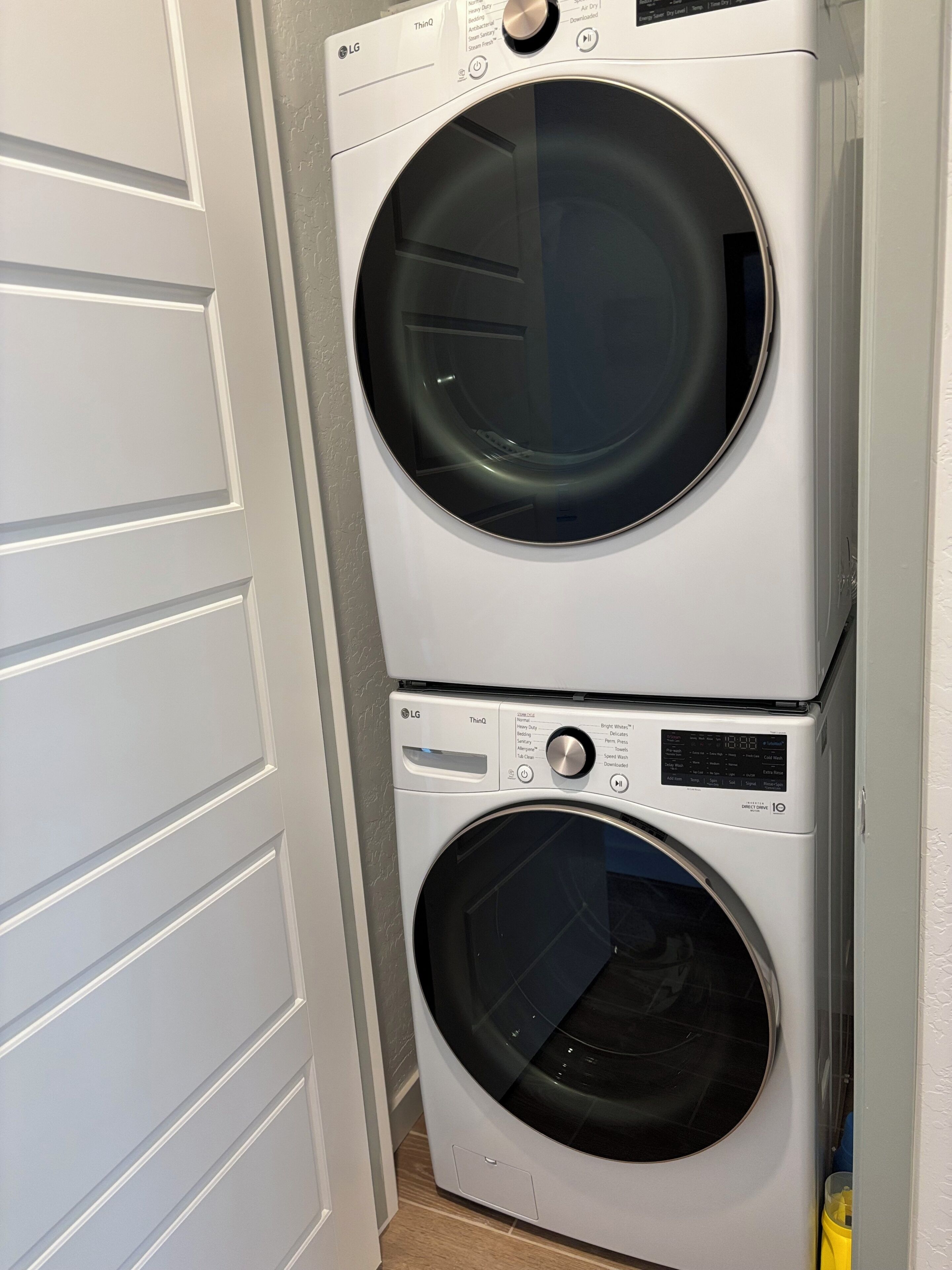 Une machine à laver et un sèche-linge superposés dans une buanderie.