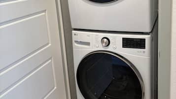 Une machine à laver et un sèche-linge superposés dans une buanderie.