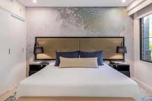 A modern bedroom with a large bed, two bedside tables, and a textured wall. - Temple Escape 3 Bed Apartment with Private Pool (Craiglie)