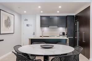 A modern kitchen with dark cabinets, a Bosch refrigerator, and a white tiled backsplash. - Temple Escape 3 Bed Apartment with Private Pool (Craiglie)