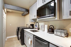 A compact kitchen with a microwave, toaster, kettle, and a coffee maker. - Modern Duplex Unit w/ Backyard, Near Transit (Seattle)