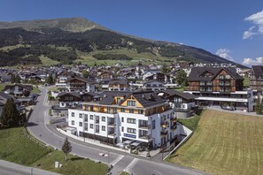 Ein Wohngebiet mit modernen und traditionellen Häusern, einer Hauptstraße und einem Berg im Hintergrund.
