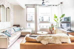 Ein modernes Wohnzimmer mit einer Couch, einem Couchtisch und einem Fernseher.