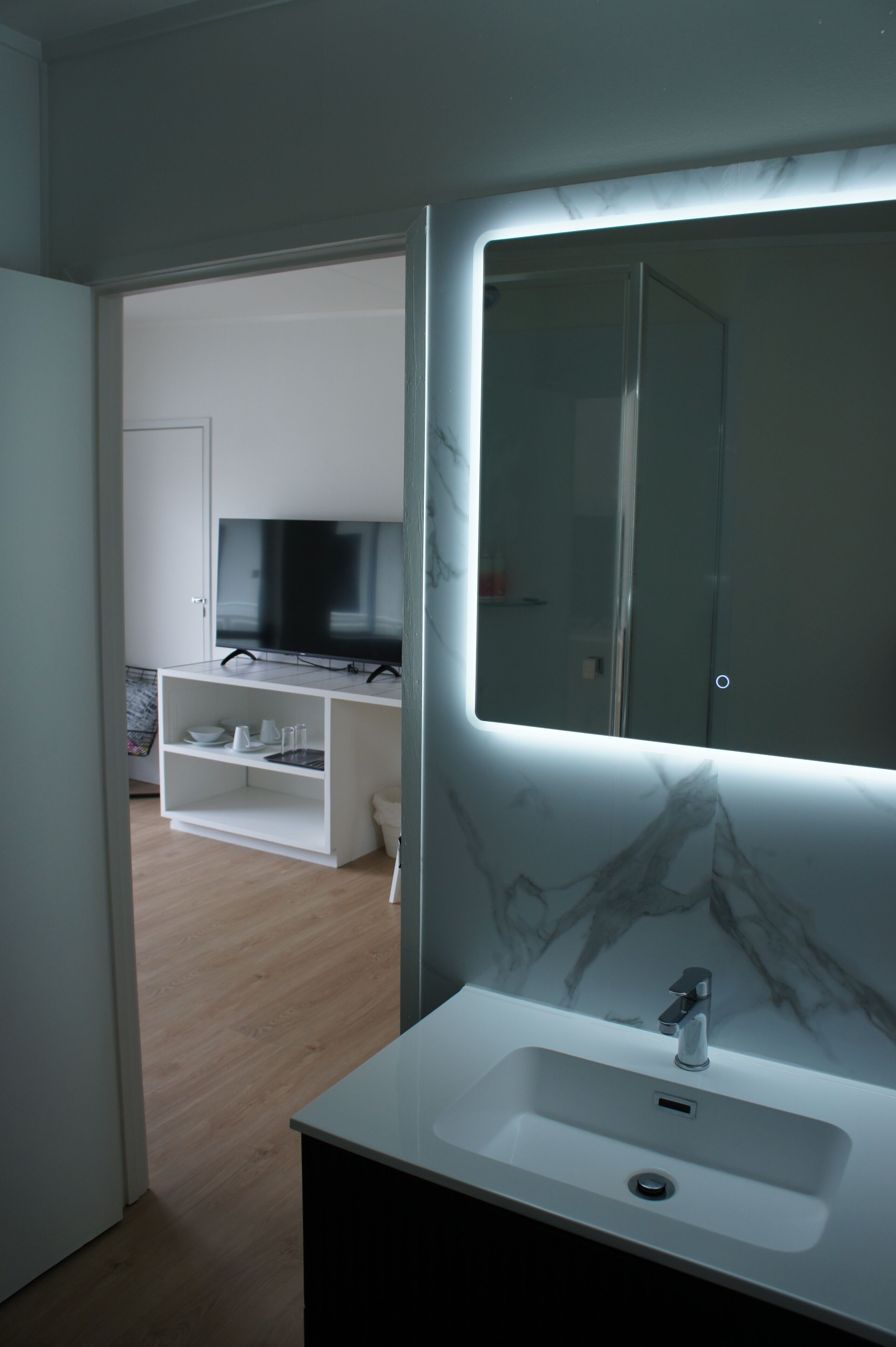 A modern bathroom with a marble sink and a large mirror.