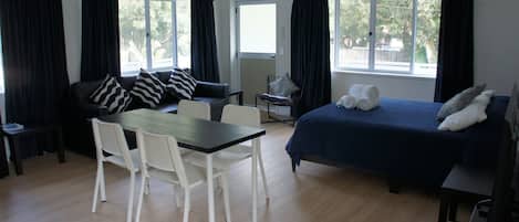 Ein Zimmer mit einem Bett, einem Tisch und zwei Stühlen.