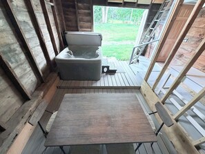 A wooden deck with a hot tub and a wooden table.