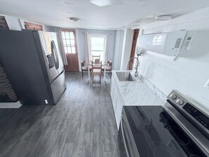 Une cuisine équipée d’un réfrigérateur, d’une cuisinière, d’un évier et d’un coin repas avec des chaises.